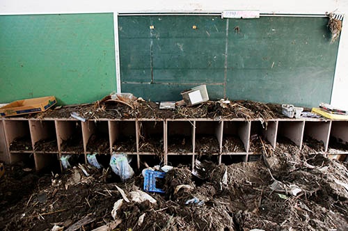 学校全体が大津波にのみこまれ、2階にまで土砂が流れ込んだ。教室や校庭、近隣を覆いつくした土砂やがれきの中から、ランドセルやヘルメットなど大量の生徒の遺品が後日発見されることになった(写真:ロイター/アフロ)