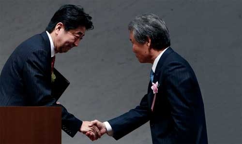 <b>経団連の榊原定征会長（右）と握手を交わす安倍晋三首相</b>（写真＝ロイター/アフロ）