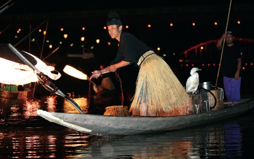 <b>広島県三次市の馬洗川で毎年開催される鵜飼いの様子。鵜匠が鵜を操って川にいる鮎を捕獲する様子を観光客が遊覧船の上から見学して楽しむ</b>（写真=三次市観光協会）