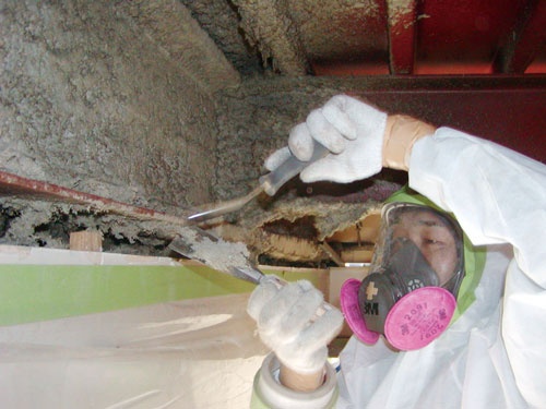 <b>ビルの柱や梁にある「吹き付け石綿」の除去工事現場。発がん性があるため防塵マスクや防護服が欠かせない</b>