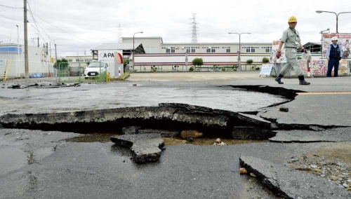 <span class="fontBold">震度6弱を観測した大阪府高槻市では道路が陥没して水道管が破裂した</span>(写真=読売新聞/アフロ)