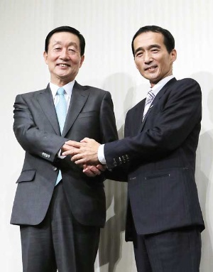 <b>握手を交わすユニーファミマの高柳社長(左)とドンキの大原社長</b>(写真=時事)