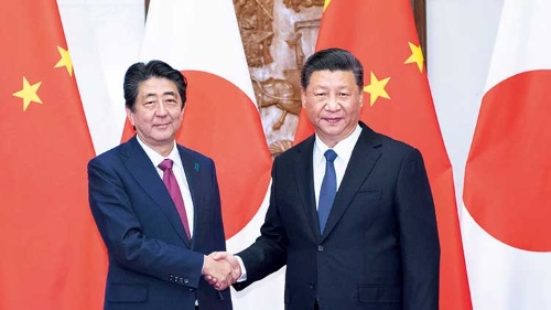 <span class="fontBold">安倍首相は中国を公式訪問し、両国の国旗が掲げられる中で習近平国家主席と握手した</span>（写真=新華社/アフロ）