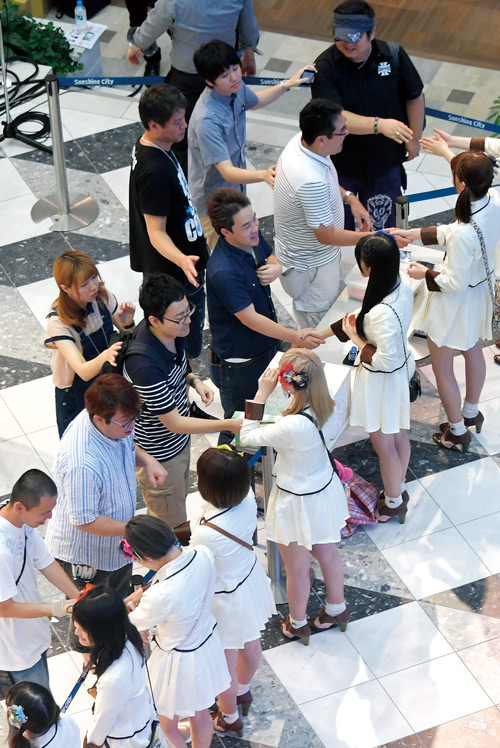 <b>アイドルの顧客対応として代表的な握手会。アイドルと直接触れ合える</b>（写真＝時事通信フォト）