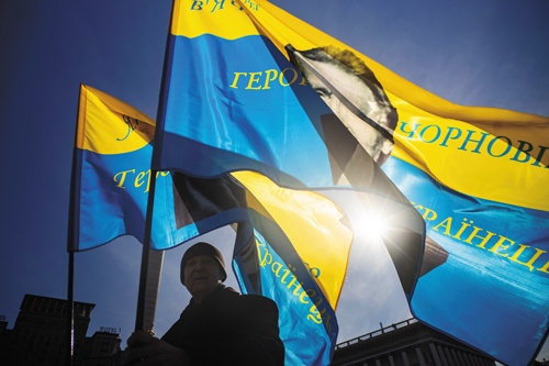ウクライナの首都キエフの独立広場で旗を掲げる男性（写真=カオル・ン）