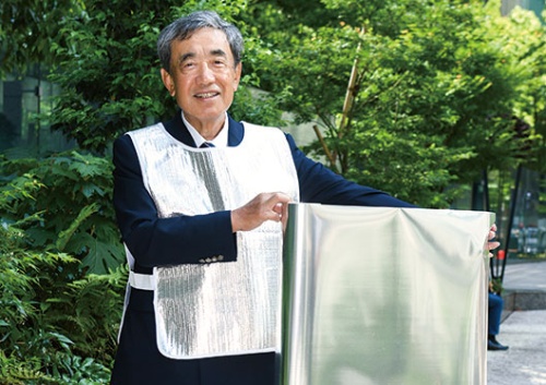 <span class="fontBold">試作の衣料品を着てフィルムを持つ松本氏。新会社の会長に就任</span>(写真=清水 真帆呂)