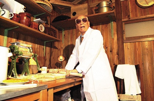 「チキンラーメン」を開発した研究小屋を模した施設でポーズを取る晩年の安藤百福氏。ベンチャー精神を象徴する施設として製作した（写真=毎日新聞社/アフロ）