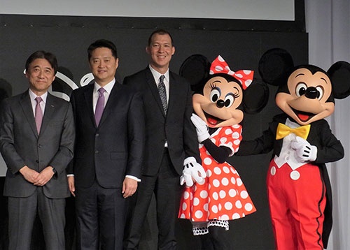 大手同士でタッグを組む（写真左はNTTドコモの吉澤和弘社長、中は米ウォルト・ディズニー・カンパニーで日本、中国、韓国を担当するルーク・カン氏）