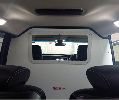 ミニバンの前部座席と後部座席の間に仕切りを設け、空調を使って気圧の違いをつくり出すことで飛沫感染を防ぐ