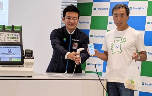 ファミリーマートの澤田貴司社長（右）は「FamiPay」のTシャツで会見に登場した