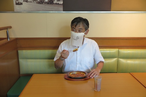 口元を隠して食事をするため、紙ナプキンとマスクを組み合わせた