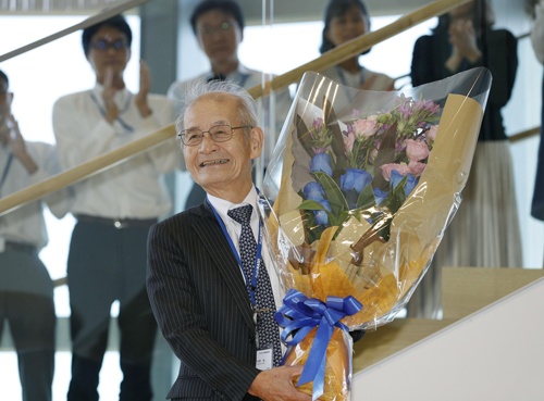 10日午前、ノーベル化学賞受賞決定から一夜明け、社員から花束を贈られ笑顔を見せる旭化成の吉野彰名誉フェロー（写真：共同通信）