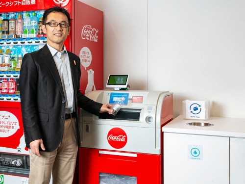 日本コカ・コーラ社内に設置されている綺麗な空容器を回収する「リバースベンディングマシーン(RVM)」。RVMの利用を通じて、社員全員がリサイクルに対する意識をさらに高め、毎日の行動に落とし込んでもらう狙いだ。(写真人物)日本コカ・コーラ 環境サステナビリティーガバナンス部長 柴田 充 氏