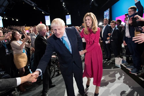 ジョンソン首相は保守党の党大会で、恋人のキャシー・シモンズと共に支持者に囲まれる （写真：代表撮影/ロイター/アフロ）
