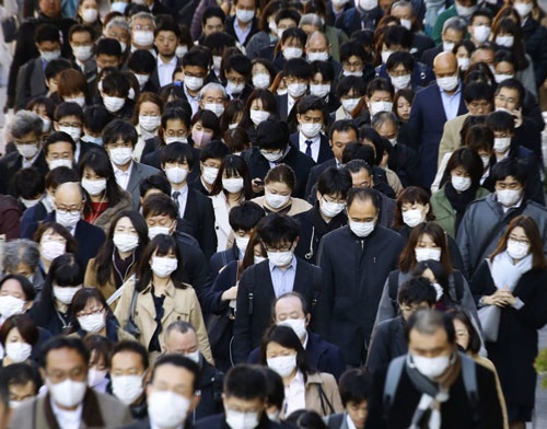 新型コロナウイルスの感染予防のため、マスク姿で通勤する人たち（写真：共同通信）