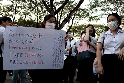 プラカードを掲げる学生。24日、チュラロンコン大学の構内で開かれた政治集会には300人ほどが参加した