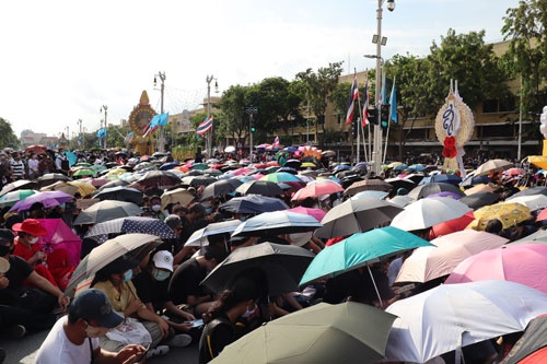 8月16日、厳しい暑さの中、強い日差しを防ぐため傘をさして反体制デモに参加する人々