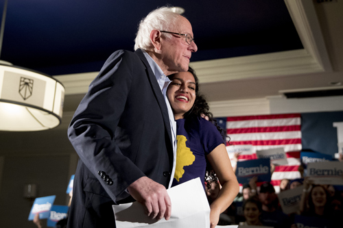 ジョー・バイデン前大統領と最後まで民主党の大統領選候補の座を争ったバーニー・サンダーズ上院議員（左）。親しそうにハグするのは、極左の環境活動団体を率いるバルシニ・プラカシュさん（27歳）（写真：AP/アフロ）