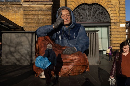 2022年末、英国のアーティストがホームレス経験者の顔を重ね合わせて、巨大彫刻を作った。インフレと景気悪化でホームレスが増えており、その警鐘を鳴らすために作品をロンドンの街角に展示した（写真：Dan Kitwood / Getty Images）