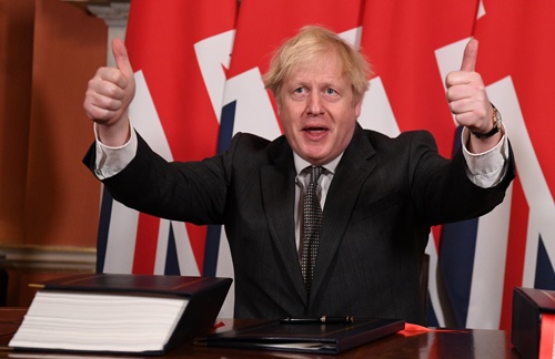 英国のジョンソン首相は2020年12月30日、EUとの自由貿易などに関する協定に署名し、誇らしげに親指を立てた(写真:代表撮影/ロイター/アフロ)
