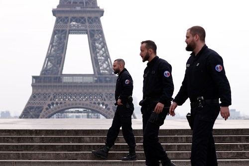 フランス政府は17日から許可のない外出を制限。パリの代表的な観光地であるエッフェル塔周辺では警官の取り締まりも（写真：ロイター／アフロ）