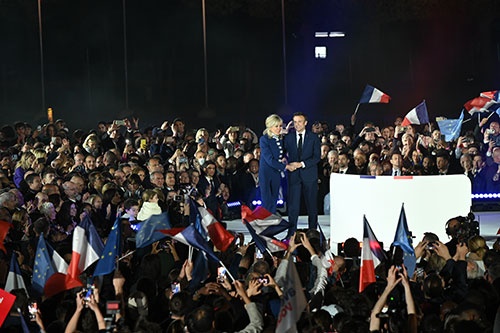 24日、フランスのマクロン大統領（写真壇上右）は決選投票で再選を決め、勝利宣言をした。壇上左は、妻のブリジットさん （写真：井田純代）