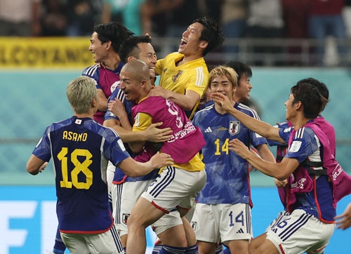 サッカーワールドカップ（W杯）カタール大会でスペインに勝利した日本代表の選手たち。中央で抱きつかれているのが吉田麻也主将（写真：AFP／アフロ）