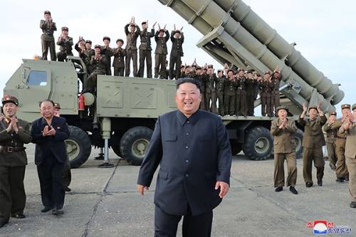北朝鮮の金正恩（キム・ジョンウン）総書記（中央）は満面の笑みで「超大型多連装ロケット砲」の発射実験を視察する（写真：KNS/KCNA/AFP/アフロ）