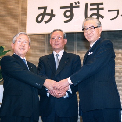 1999年、３行統合による「みずほフィナンシャルグループ」を創設し、握手する（左から）富士銀行・山本恵朗、第一勧業銀行・杉田力之、日本興業銀行・西村正雄の３頭取（写真＝共同通信）