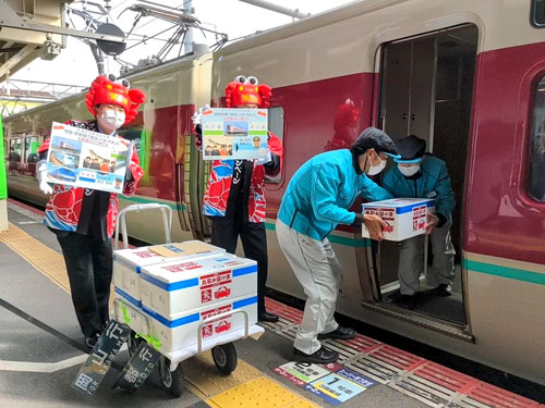 米子駅では2人の係員の連携プレーで短い停車時間内に5箱を積み込んだ