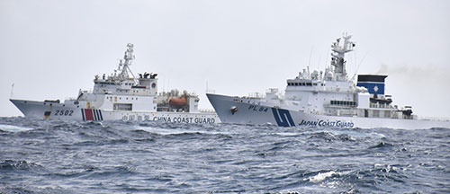 沖縄県・尖閣諸島付近で並走する中国海警局の船（左）と海上保安庁の巡視船（提供元：共同通信）