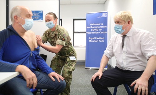 英国のジョンソン首相(右)が新型コロナウイルス用ワクチンの接種会場を視察。英国では3回目の接種が進んでいる(写真:ロイター/アフロ)