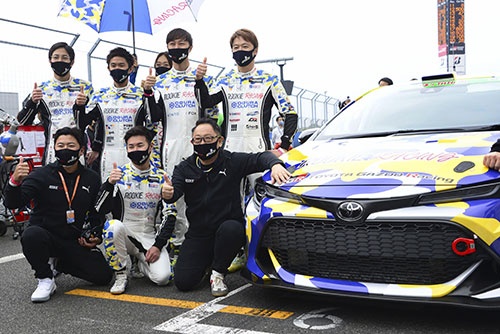水素エンジンを搭載したレースカーと記念撮影するトヨタ自動車の豊田章男社長(前列右、写真:共同通信)