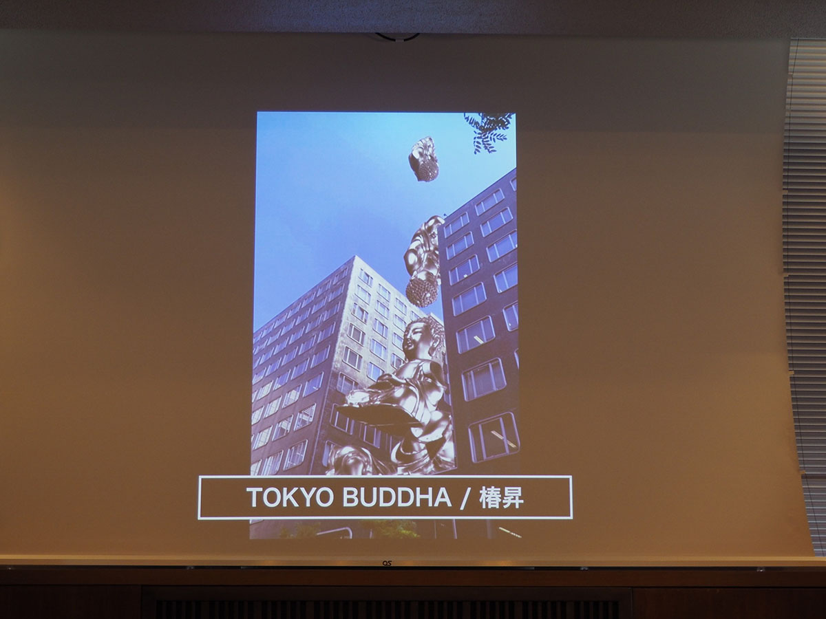 椿昇氏の作品「TOKYO BUDDHA」は、ビルの谷間にブッダが次々と落下し、最後には溶けて金塊になるという表現を、AR技術と「PLATEAU」のデータを使って実現している。写真は2021年6月29日の「東京ビエンナーレ2020／2021」に出展するARアートの共同開発に関する記者説明会より（筆者撮影）
