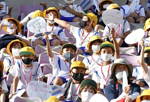 東京五輪のサッカーの試合を観戦する小学生ら。牛窪氏はα世代が固定概念に縛られないように、偶然の出合いを生み出す仕組みが重要と説く（写真：共同通信）