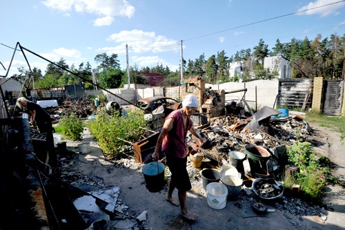 水を運ぶ、自宅を破壊されたキーウの住人(写真=AFP/アフロ)