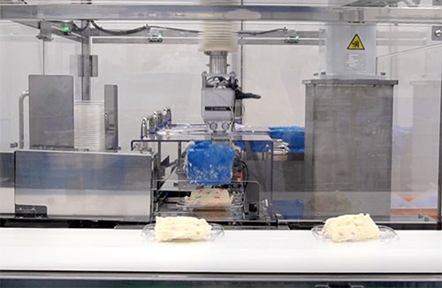 ポテトサラダを決まった量ごとにロボットが盛り付ける（静岡県長泉町のマックスバリュ東海デリカ長泉工場）