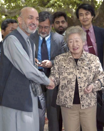 カルザイ・アフガニスタン大統領と握手する 緒方貞子氏（2003年7月、カブールで）（写真：共同通信）