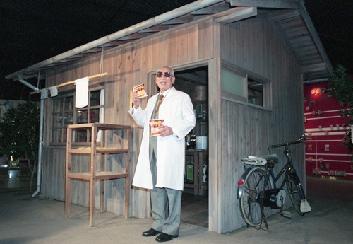 「チキンラーメン」を開発した研究小屋を模した施設の前で話す安藤百福氏（写真：共同通信、1999年）