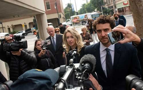 11月18日に米カリフォルニア州の連邦地裁に入るエリザベス・ホームズ被告(中央)(写真:Bloomberg / Getty Images)