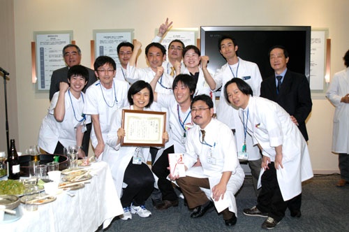 発表会の優勝を喜ぶチームとともに(上段右から1人目が石田氏、上段左から1一人目は理事長だった草刈隆郎氏、写真は石田氏提供)