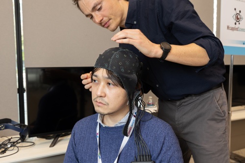 キャップの後頭部に付いている8つのセンサーが、脳波を読み取る（写真＝的野 弘路）