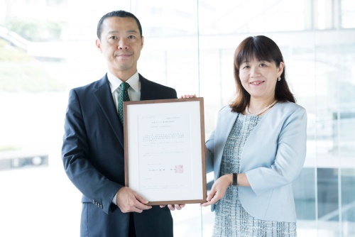 リンクルショット開発者のポーラ・オルビスホールディングス執行役員の末延則子さん(右)。手にしているのは、厚生労働省による医薬部外品製造販売承認書。申請から8年かけて、日本初のシワに効く薬用化粧品として厚生労働省に承認された。左はポーラ社長の横手喜一(よしかず)さん(撮影/窪徳健作)。