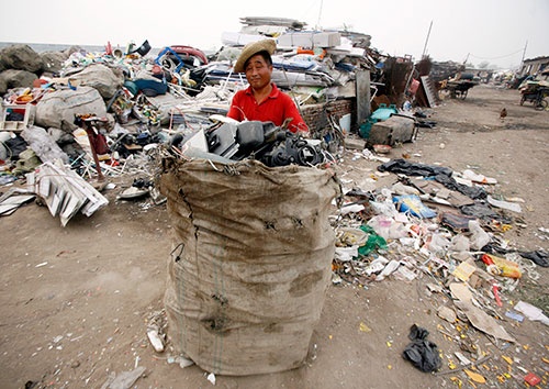 2009年当時、北京郊外のリサイクルセンターで約30元相当のリサイクル可能なゴミの袋をトラックに積む準備をする作業員（写真：ロイター/アフロ）