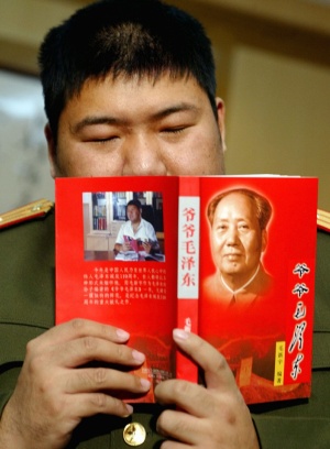 32歳の時、祖父・毛沢東について書いた自著を持つ毛新宇氏（写真：ロイター/アフロ）