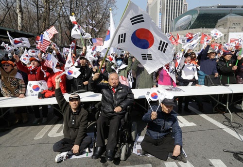 朴氏の支持者が集まり、弾劾決定に抗議。座り込みをする人も(写真:AP/アフロ)