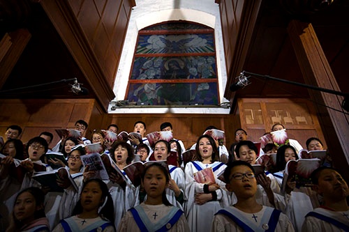 3月31日、中国・北京にある政府に認可された教会で賛美歌を歌う合唱団 （写真：AP/アフロ）