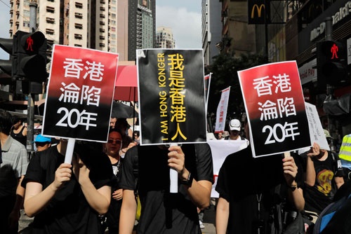 7月1日、香港返還20年の節目に行われた民主化要求デモでは「自分は香港人」「香港占領20年」をアピールするプラカードを持った若者の姿が。反中感情は高まっているが、デモ参加者は激減。その理由は…(写真:AP/アフロ)