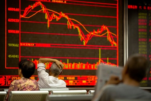 米中貿易戦争が勃発した7月6日、株価を見つめる中国・北京の投資家たち(写真:AP/アフロ)