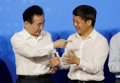 7月19日、王健林（写真左）率いる大連万達が、孫宏斌率いる融創中国へ娯楽事業を売却、北京で調印式を行った。政商たちそれぞれの思惑や如何に（写真：ロイター/アフロ）